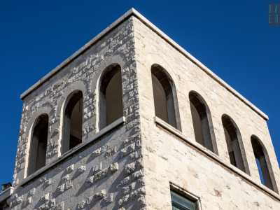 Chiude il prospetto un cornicione sorretto da mensole e un torrino con loggia ad archi che reinterpreta le forme classiche e romaniche
